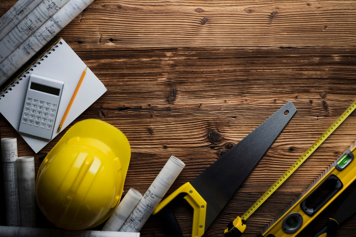 tools and blueprints on wood background