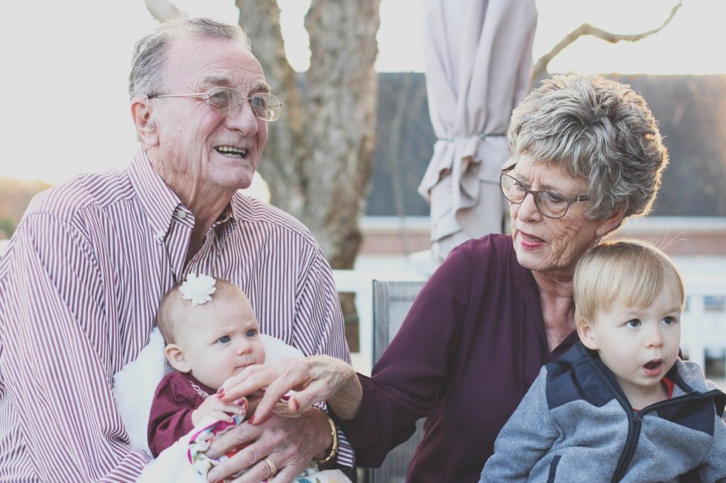 Grandparents holding their infant grandchildren